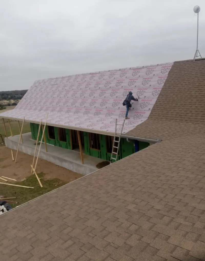 Worker preparing underlayment for a metal roof installation in Winter Springs